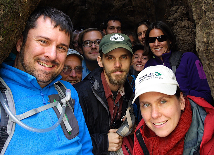 Group of people huddled under a cave-like opening.